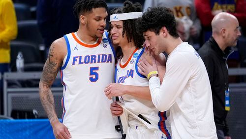 Florida guard Walter Clayton Jr., center, walks off the court with teammate guard Will Richard (5) after a first-round college basketball game against Colorado in the NCAA Tournament, Friday, March 22, 2024, in Indianapolis. Colorado won 102-100. (AP Photo/Michael Conroy)