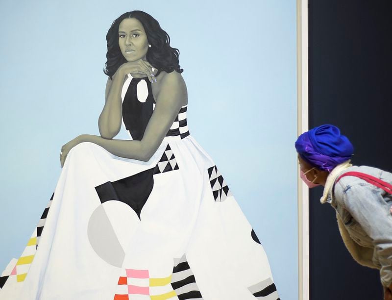 A patron examines artist Kehinde Wiley’s oil painting of former first lady Michelle Obama during opening day of the Obama Portraits Tour Friday, Jan. 14, 2022 at the High Museum of Art. (Daniel Varnado/For the Atlanta Journal-Constitution)