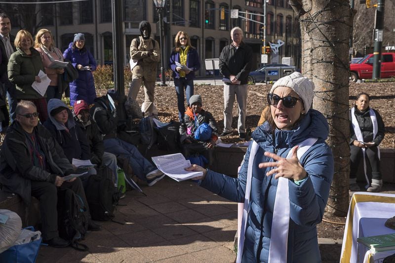The Rev. Monica Mainwaring, vicar at Church of the Common Ground, presents the word during a Church of the Common Ground Christmas Eve service for the homeless at Woodruff Park in Atlanta on Monday, December 24, 2018.