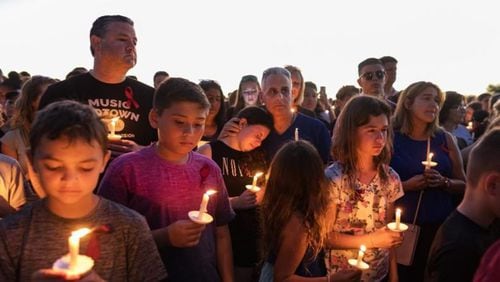 People attend a candlelit memorial service Thursay night for the victims of the shooting at Marjory Stoneman Douglas High School that killed 17 people.