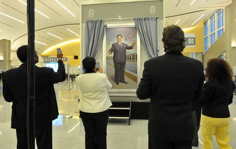 Guests grab a shot of the portrait of Maynard H. Jackson Jr. Hyosub Shin/hshin@ajc.com