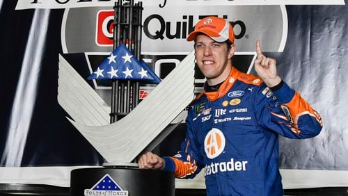 Brad Keselowski poses with the trophy in victory lane after winning a NASCAR Monster Cup series auto race at Atlanta Motor Speedway Sunday.