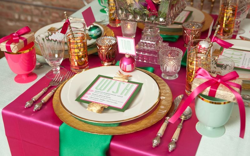 Pretty in Pink: Despite a departure from typical Christmas colors, this tablescape captures a celebratory holiday mood through use of pink and green satin linens from BBJ Linens and jewel-toned glassware and dishes. Decorative accents like the small gift boxes and holiday bulbs add sparkle to this dazzling display.