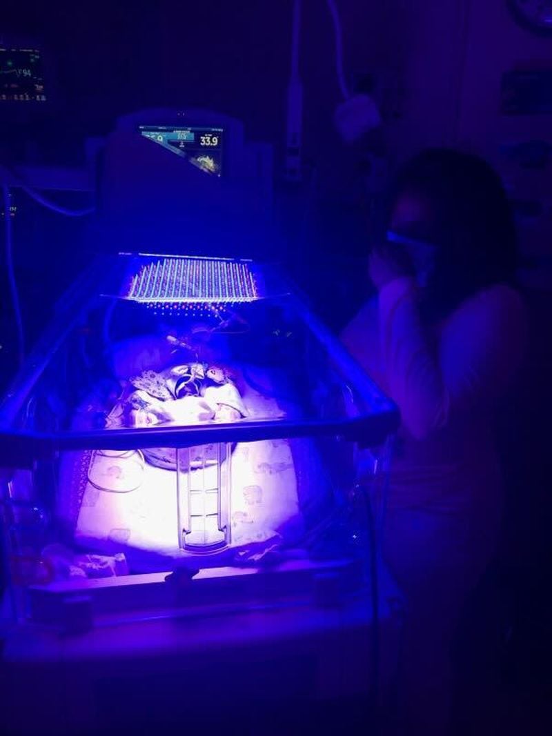 Audreona Scott prays over Jayla, who is in a baby incubator, a controlled, enclosed and dimly lit environment designed to create conditions similar to the womb. (Contributed)