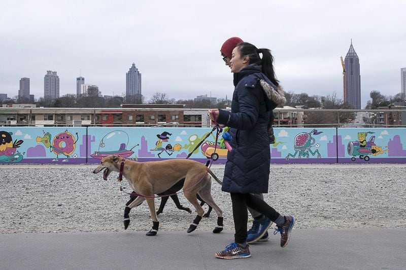 Pedestrians enjoy a walk with their dogs along the Atlanta Beltline during a chilly, cloudy afternoon in Atlanta, Thursday, December 27, 2018. Rain is in the forecast for late Thursday afternoon and evening in metro-Atlanta.