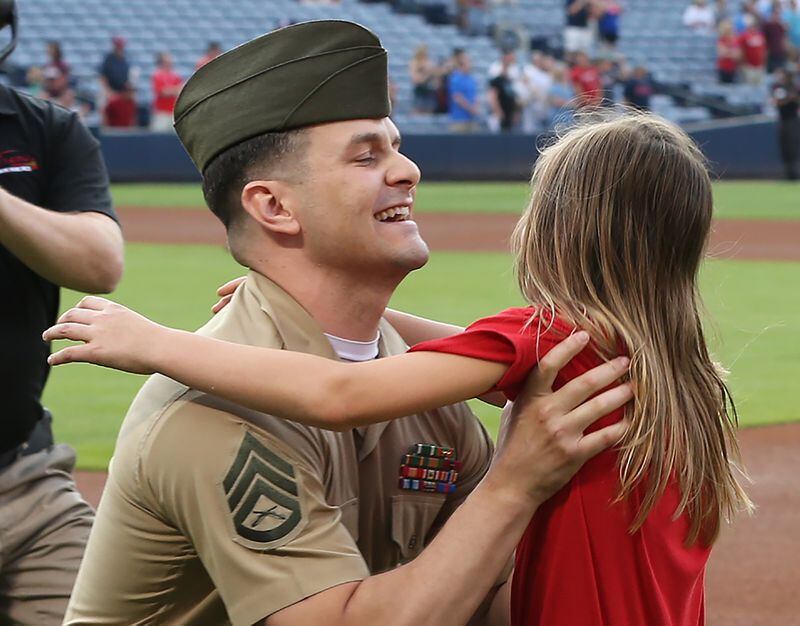 051116 ATLANTA: U.S. Marine Corps SSG Clayton Walker is reunited with his daughter Cassidy, 10, Langston Elementary School, Perry, GA, after his fifth tour of duty just before the first pitch in the Braves and Phillies baseball game at Turner Field on Wednesday, May 11, 2016, in Atlanta. Curtis Compton / ccompton@ajc.com