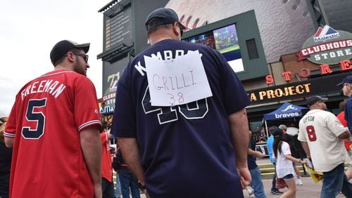 Ayron Dent, of Temple, covers up his Craig Kimbrel jersey shirt with new relief pitcher Jason Grilli (39) before the Atlanta Braves home opener Friday, April 10, 2015, against the New York Mets at Turner Field in Atlanta.