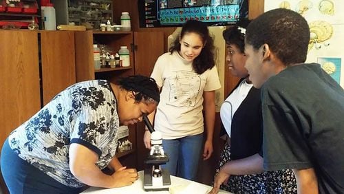 In addition to math, Angela Paul teaches science. Here, she's in the biology lab with students Joan Deitsch (from left), Adrianna Cauthen and Brandon Bosley.