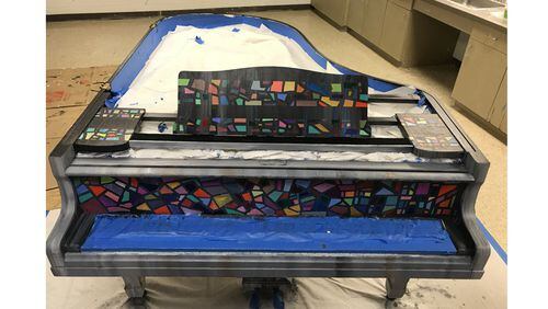 “Ekphrasis,” being painted and prepped as the first baby grand piano installed in a public place by the Play Me Again Pianos nonprofit, is to debut Aug. 24 in Alpharetta. PLAY ME AGAIN PIANOS