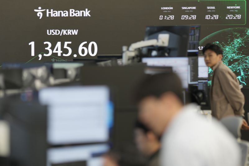 A currency trader walks by the screen showing the foreign exchange rate between the U.S. dollar and South Korean won at a foreign exchange dealing room in Seoul, South Korea, Thursday, April 4, 2024. Asian shares mostly rose Thursday after a firm finish on Wall Street, as expectations remained solid for U.S. interest rate cuts this year. (AP Photo/Lee Jin-man)