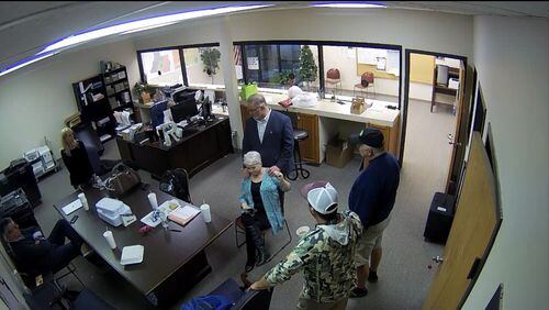 Surveillance video of the Coffee County elections office shows election skeptic Scott Hall giving county Republican Party Chairwoman Cathy Latham a massage on Jan. 7, 2021, the day tech experts copied confidential voting data. Also pictured are Paul Maggio and Jennifer Jackson of SullivanStrickler, county elections board member Eric Chaney and an unidentified man. Source: Coffee County