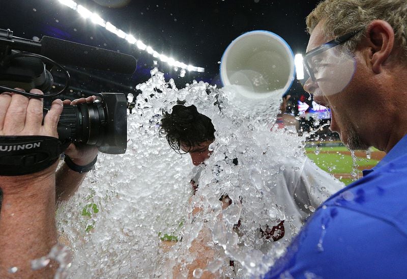 While giving an interview after his game-winning hit, Dansby Swanson is drenched with ice water.