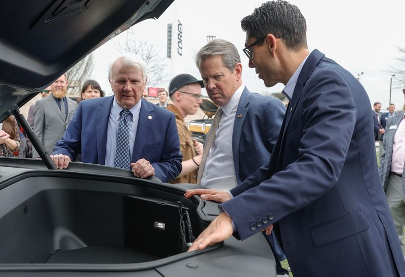 From left, Georgia Speaker of the House Jon Burns, Gov. Brian Kemp, and Rivian CEO RJ Scaringe look inside of the trunk of a Rivian electric vehicle at the Georgia State Capitol on March 1, 2023. Other Republicans are blasting EVs. (Natrice Miller/The Atlanta Journal-Constitution)