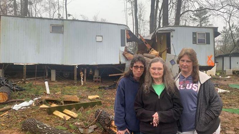 Joanne Mathis (center) and her daughters, Tonia Dalton (left) and Angela Cook (right), stand in front of what remains of Mathis' home on Cherokee Drive in Butts County. (Photo Courtesy of Sharon Dowdy Cruse)