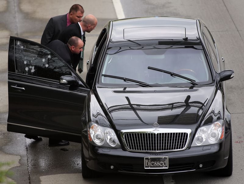 DeKalb County Police detectives inspect a black Maybach on I-20 just West of the Glenwood Avenue overpass on Thursday evening April 11, 2013. A man was found shot in the car, which was parked partially in the right travel lane. BEN GRAY / BGRAY@AJC.COM