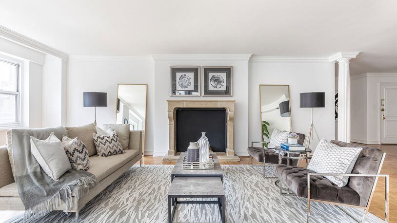 A large gray area rug helps ground this large living room. Gray chairs complete the look. (Design Recipes)