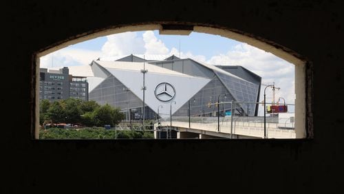 Mercedes-Benz Stadium is shown through a window inside the Lofts at Centennial Yards in downtown Atlanta, Friday, August 5, 2022. (Jason Getz / Jason.Getz@ajc.com)