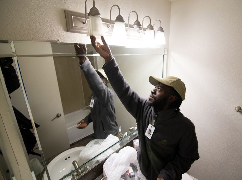 Moma Sayplay replaces light bulbs while preparing an apartment for renting at the Gables Mills Apartments Monday, February 10, 2020.  STEVE SCHAEFER / SPECIAL TO THE AJC