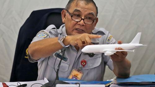 Indonesian National Transportation Safety Committee chief Tatang Kurniadi speaks with a model plane of AirAsia Flight 8501 that crashed into the Java Sea on Dec. 28 last year during a press conference in Jakarta, Indonesia Thursday, Jan. 29, 2015. On Dec. 1, 2015, an investigation concluded that at least one faulty plane part and crew behavior led to the plane going down, killing everyone on board. (AP Photo/Dita Alangkara)