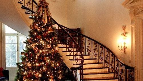 The halls and spiral staircase at the Swan House at the Atlanta History Center are decked for Christmas.