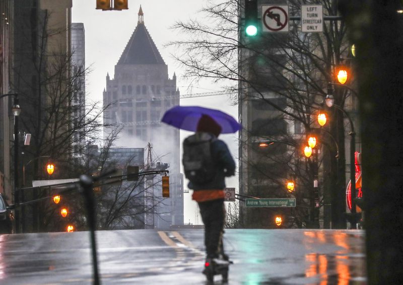 A scooter rider on Peachtree Street in January 2021. (John Spink / John.Spink@ajc.com)
