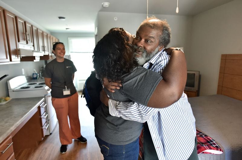 Stephanie Dotson gets a hug from her client Willie Franks, right, as Mercy Care street medicine team members visit to check their clients at Phoenix House, affordable housing complex reserved for the homeless and mentally disabled, in Atlanta. (Hyosub Shin / Hyosub.Shin@ajc.com)