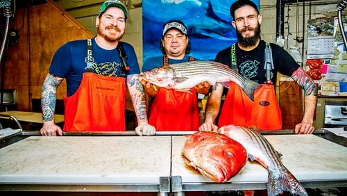 Tim Reynolds, senior fishmonger, Henry Dewey, owner, and Kyle Houghtelin, fishmonger, pose for a portrait behind the counter at Penn Avenue Fish Company in the Strip District. (Andrew Rush/Pittsburgh Post-Gazette/TNS)