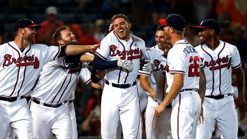 Atlanta Braves' Freddie Freeman, center, and teammates celebrate after Freeman hit a home run against the San Francisco Giants in the 11th inning of a baseball game, Wednesday, June 1, 2016, in Atlanta. The Braves won 5-4. (AP Photo/Butch Dill)