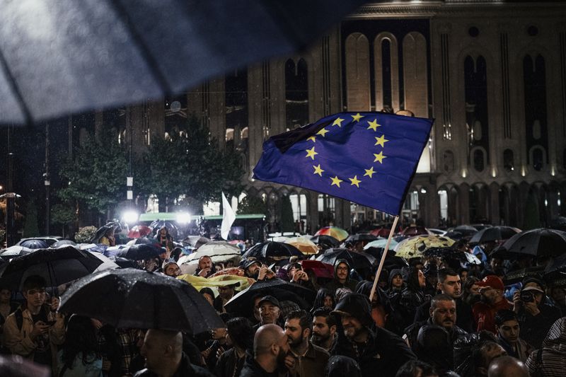 Protesters outside the Parliament of Georgia in Tbilisi wave a European Union flag as they demonstrate in May against the resumption of direct flights from Russia to the former Soviet republic. Russia invaded its neighbor in 2008, and the two countries remain in perennial struggle. (Tako Robakidze/The New York Times)
                      