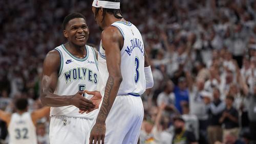 Minnesota Timberwolves forward Jaden McDaniels (3) celebrates with guard Anthony Edwards (5) after making a 3-point basket during the second half of Game 6 of an NBA basketball second-round playoff series against the Denver Nuggets, Thursday, May 16, 2024, in Minneapolis. (AP Photo/Abbie Parr)