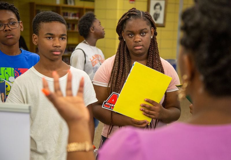 (left to right, all CQ) Curtis Evans, Jeremiah Williams and Siera McMullin listen to a college recruiter during a college and career expo hosted at Fredrick Douglass High School, in Atlanta, on Wednesday, July 24, 2019, as part of a program targeting recent Atlanta high school graduates. (Photo by Phil Skinner)