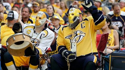 Nashville Predators fans Scott Sulfridge, left, and Chris Rickman, right, cheer as they watch the Predators play the Pittsburgh Penguins in Game 1 of the NHL Stanley Cup Finals at one of several viewing areas set up Monday, May 29, 2017, in Nashville, Tenn. (AP Photo/Mark Humphrey)
