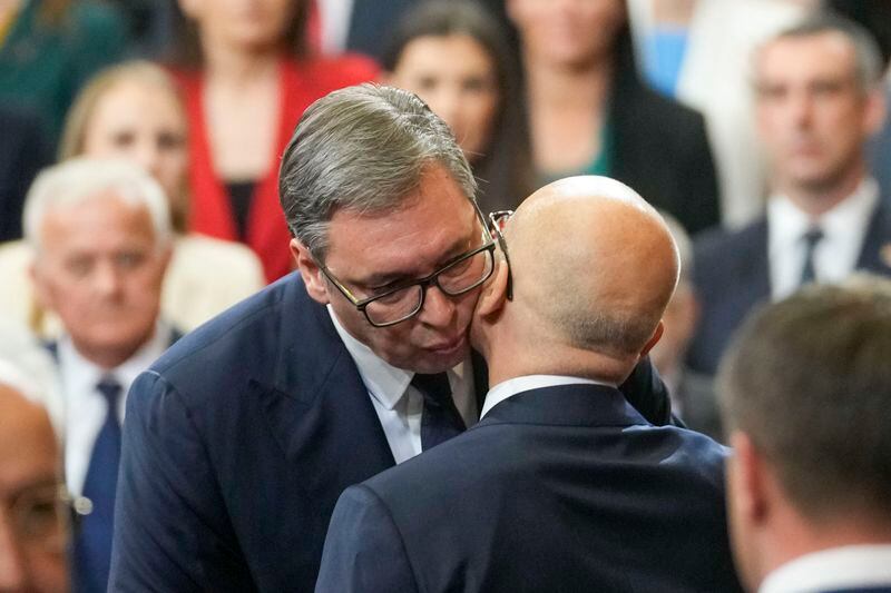 Serbian President Aleksandar Vucic, left, kisses Serbia's new Prime Minister Milos Vucevic after taking the oath during the cabinet's swearing in ceremony at the Serbian Parliament building in Belgrade, Serbia, Thursday, May 2, 2024. Serbian lawmakers on Thursday voted into office a new government that reinstated two pro-Russia officials who are sanctioned by the United States, reflecting persistent close ties with Moscow despite the Balkan nation's proclaimed bid to join the European Union. (AP Photo/Darko Vojinovic)