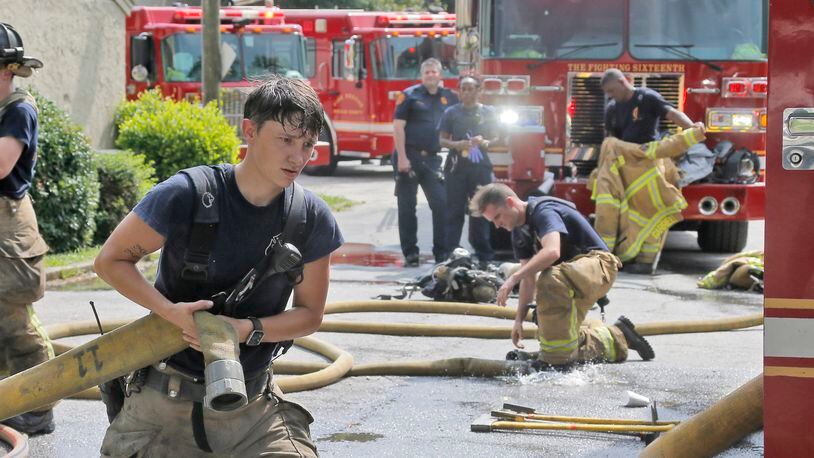 DeKalb firefighters do their best to keep cool in hot, humid afternoon temperatures as they battle an apartment fire on July 25, 2017.  BOB ANDRES  /BANDRES@AJC.COM