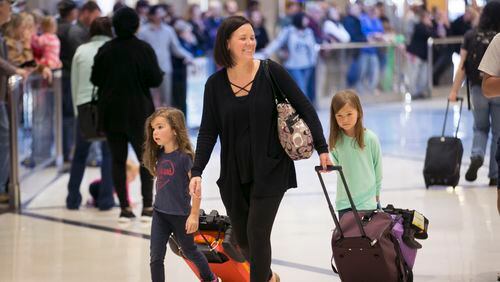 Elizabeth Sarnowski and daughters Sofia (left) and Stella, both 5, arrive from Cleveland at Hartsfield-Jackson Atlanta International airport to spend the holiday with relatives in Atlanta. BOB ANDRES /BANDRES@AJC.COM