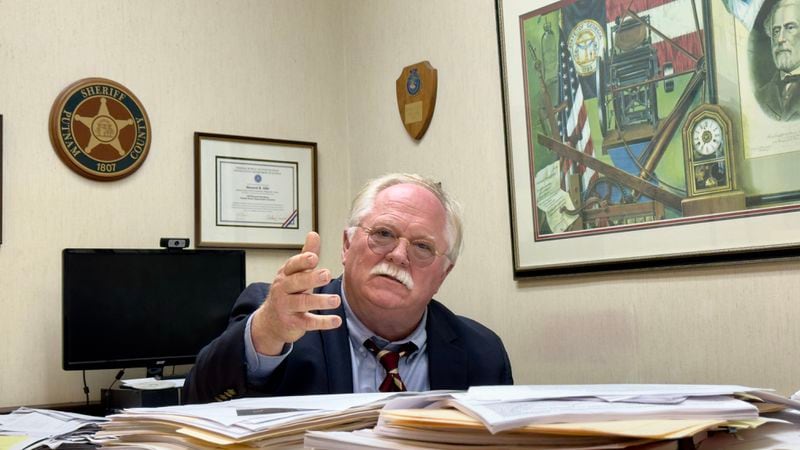 Putnam County Sheriff Howard Sills at his desk in Eatonton, where daily he continues to pore over details in the unsolved 2014 slayings of Lake Oconee residents Shirley and Russell Dermond. (Joe Kovac Jr. / AJC)