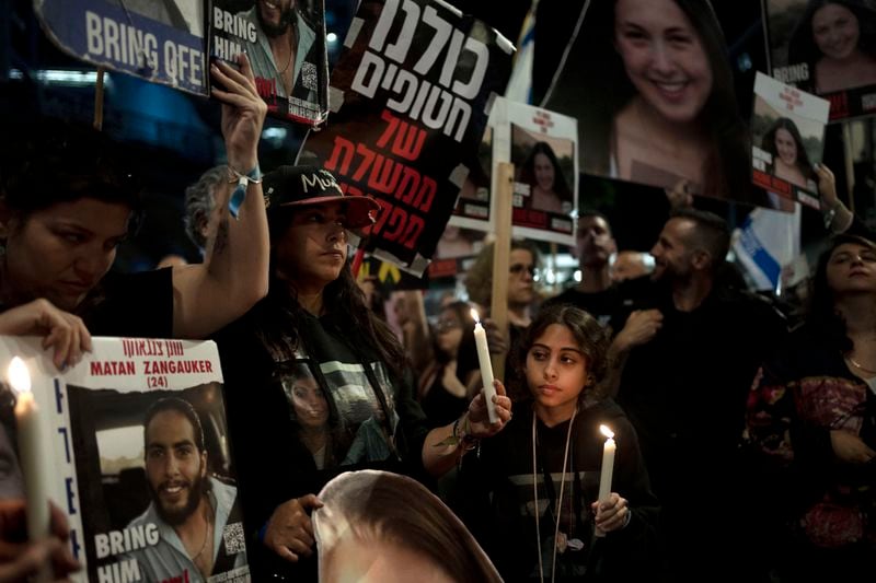 Released hostage Ilana Gritzewsky, center, whose boyfriend, Matan Zangauker, held hostage by Hamas in the Gaza Strip, stands with Matan's family at a march to call on Israeli Prime Minister Benjamin Netanyahu's government to make a deal to free their loved ones, in Tel Aviv, Israel, Wednesday, May 8, 2024. (AP Photo/Maya Alleruzzo)