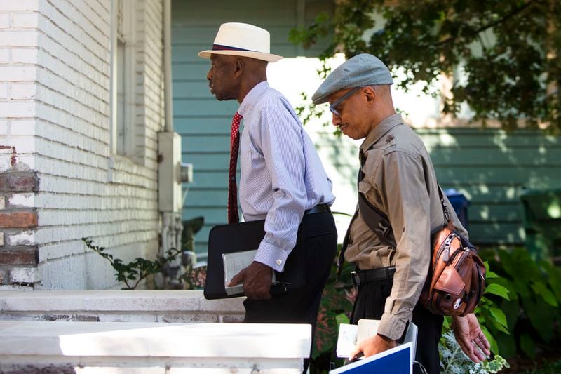 Walter Delaney (left) and Sam Hall (right), Jehovah's Witnesses, go door-to-door, Bibles in hand in Atlanta.  The group resumed their door-to-door ministry after pausing for two-and-a-half-years due to the coronavirus pandemic. CHRISTINA MATACOTTA FOR THE ATLANTA JOURNAL-CONSTITUTION.