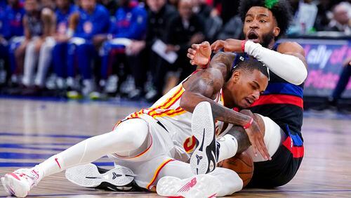 Atlanta Hawks guard Dejounte Murray (5) and Detroit Pistons forward Saddiq Bey (41) get tangled up during the first half of an NBA basketball game, Wednesday, Oct. 26, 2022, in Detroit. (AP Photo/Carlos Osorio)