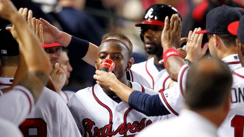 It's hard to see him in this Aug 1, 2013, photo but Atlanta Braves starting pitcher Kris Medlen is giving right fielder Justin Upton a drink of water after his home run against the Colorado Rockies in the eighth inning at Turner Field.