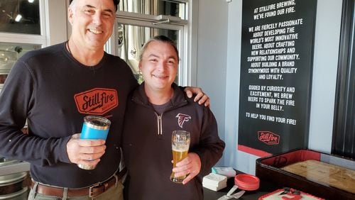 StillFire brewmaster Phil Farrell (left) with Matt Savitt, a regular customer who was celebrating with a beer and a cake for 100 consecutive days visiting the brewery. CONTRIBUTED BY STILLFIRE BREWING