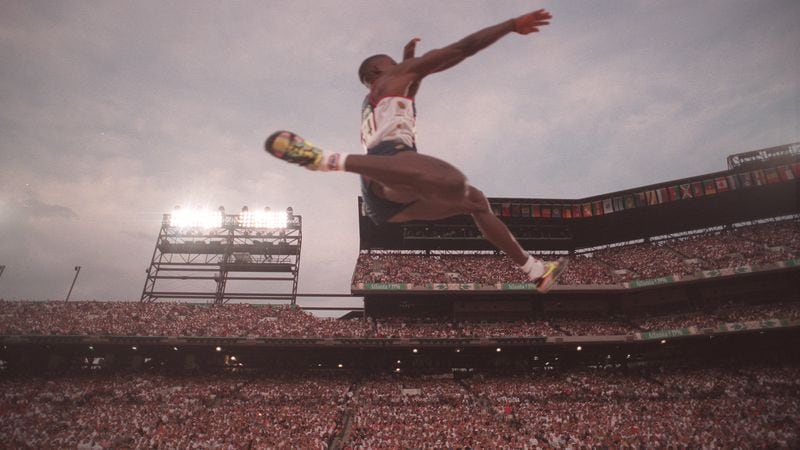 American Carl Lewis soars into first place during the long jump competition of the 1996 Atlanta Olympics on July 29, 1996, at Olympic Stadium in Atlanta. (Rich Addicks/AJC)