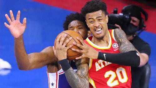 Hawks forward John Collins battles for the ball with Philadelphia 76ers center Joel Embiid during Game 2 of the Eastern Conference semifinals Tuesday, June 8, 2021, in Philadelphia. (Curtis Compton / Curtis.Compton@ajc.com)