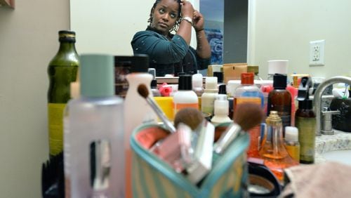 Jasmine Jacobs uses many hair products to do her daily hair treatment at her home in Atlanta on Tuesday, April 2, 2014. Jasmine Jacobs, six years into what she thought was a promising and long military career, said she was finally done in by the one thing that was always natural to her - her hair. Jacobs railed against a new policy that places heavy restrictions on how women can and cannot wear their hair in the military. HYOSUB SHIN / HSHIN@AJC.COM
