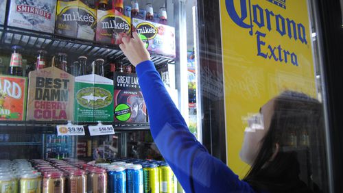 Fairfield High School Youth Coalition member Lindsey Ollis affixes warning labels to multipack containers of beer and wine coolers at Dixie Foodmart on Ohio 4 in Fairfield Sunday, March 20, 2016. The effort was the first installment in 2-day Sticker Shock initiative launched by Coalition for a Safe and Drug-Free Fairfield to educate the public and change attitudes about buying for and serving alcohol to anyone under the age of 21. ERIC SCHWARTZBERG/STAFF