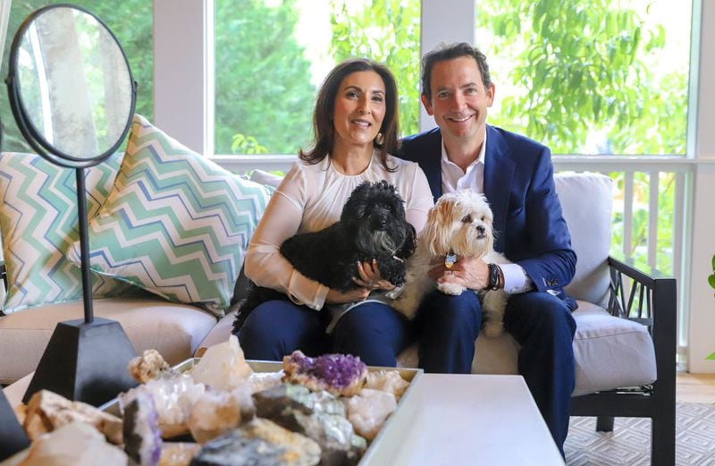 Anisa Telwar Kaicker, founder and CEO of global makeup brush brand Anisa International, and Arjun Kaicker, an artist and architect, hold their adopted poodle-mix dogs, Bo and Belle, on their covered porch.