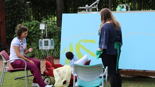 A Children's Healthcare of Atlanta at Egleston patient works on part of the new mural.