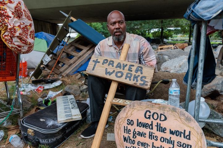 Thomas Lecky, 41, displays with his artwork at a homeless encampment in downtown Atlanta on Thursday, August 25, 2022. The city and the nonprofit Partners for HOME plan to shut down the encampment before Labor Day and find housing for the residents. Making art “centers me and reminds me of my purpose,” says Lecky. “If I didn’t have occupations and things that I do out here, I wouldn’t be able to survive.” (Arvin Temkar / arvin.temkar@ajc.com)