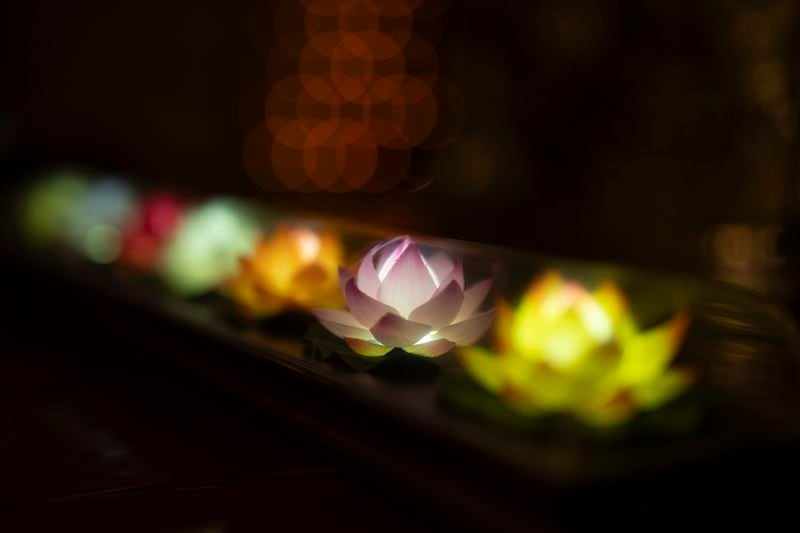 Lights illuminate a display of multicolored faux lotus flowers at the Iu Mien Buddha Light Temple on Tuesday, April 30, 2024, in Gresham, Ore. There is a sizeable Iu Mien community in Portland and its suburbs, with a Buddhist temple and Baptist church, active social organization, and businesses and restaurants. (AP Photo/Jenny Kane)
