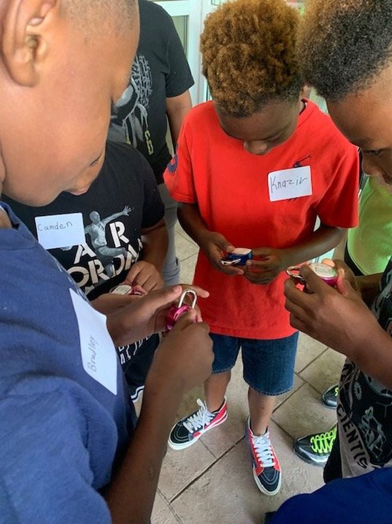 Incoming sixth-graders practice using a combination lock during a back-to-school readiness event for students in south Fulton County organized by Takeshia Berkely, a former school counselor whose own daughter also is entering sixth grade this year. PHOTO SUBMITTED BY TAKESHIA BERKELEY